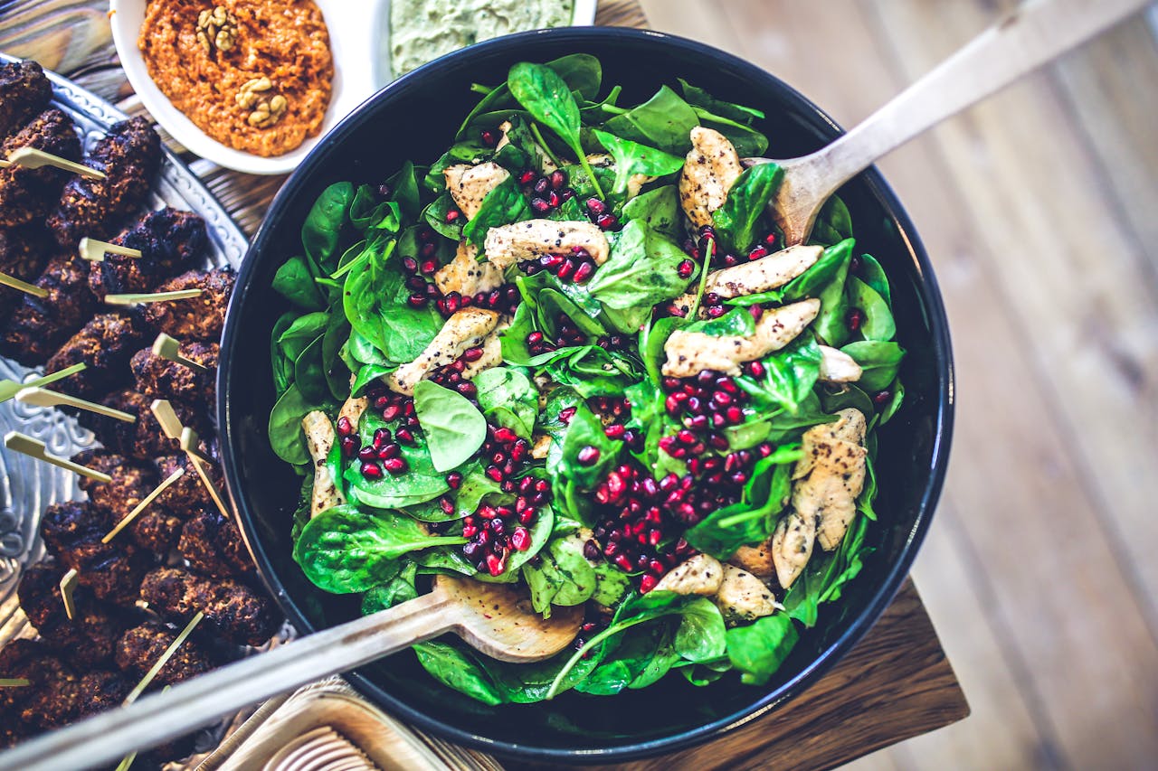 Healthy and vibrant spinach salad with grilled chicken and pomegranate seeds, perfect for a nutritious meal.